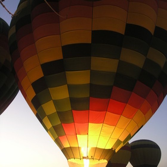 Tethered hot air balloons are illuminated during a "balloon glow."