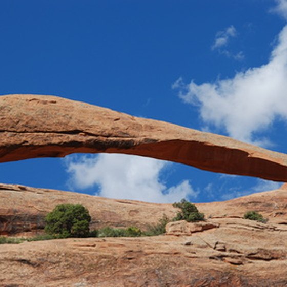 A sandstone arch creates a window in the rock.