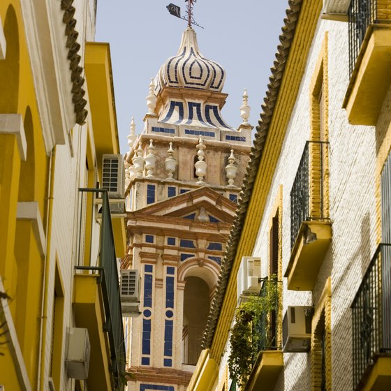 Narrow streets and ornate architecture can be seen in Seville, Spain.