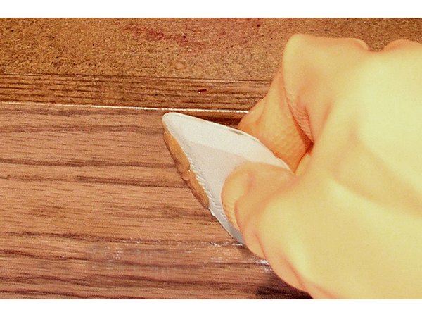 Use a variety of plastic scraper sizes and shapes to fit the contours of the piece you are stripping.