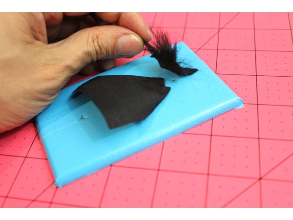 The witch's head flaps over the screw hole