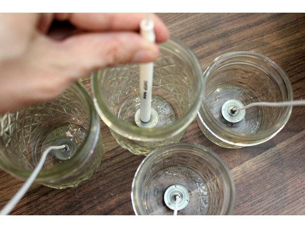 Place the wicks in the containers