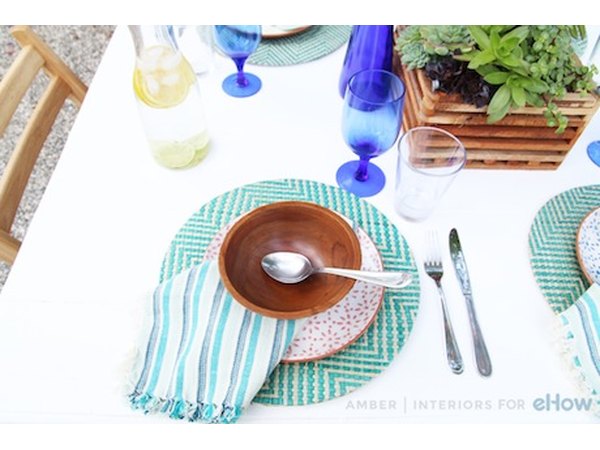 Don’t be afraid to mix patterns and textures: a turquoise striped napkin paired with a wooden bowl feels creative and unexpected.