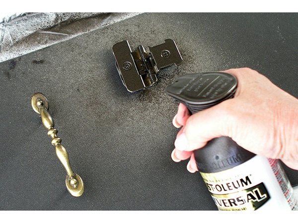 Stand handles on their screws pushed into foam board to paint.