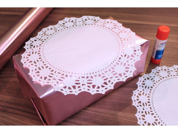 Adhere paper doilies to box