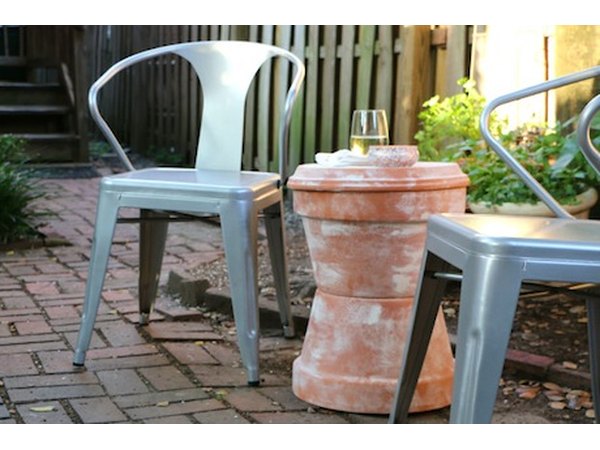 An accent table and chairs create an intimate patio nook for enjoying a glass of wine and hors d'oeuvres.
