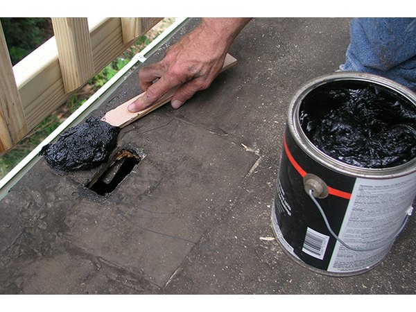 Spread the roofing cement all around the hole.