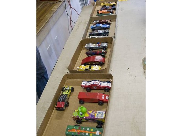 Pinewood derby cars sorted in boxes wait for their race.