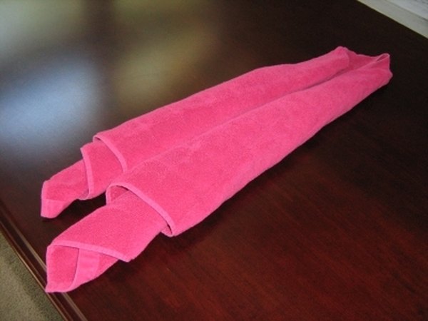 Rolling the folded ends to the center.