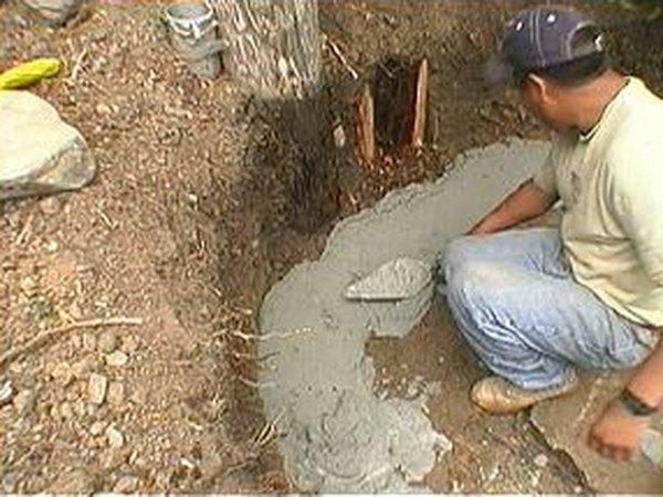 Mortar is spread into a trench for a curved bench.