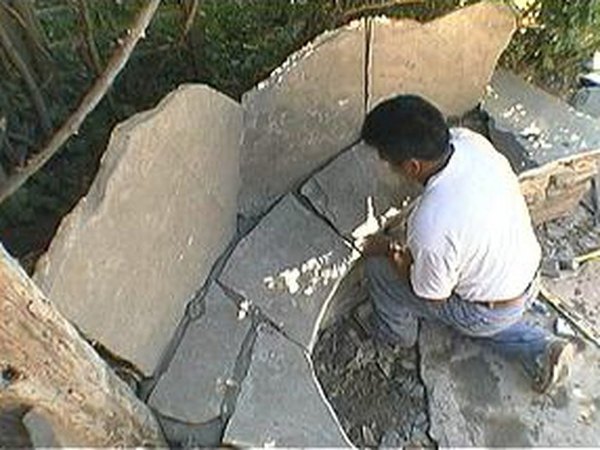 Place smaller flagstone pieces on the base.