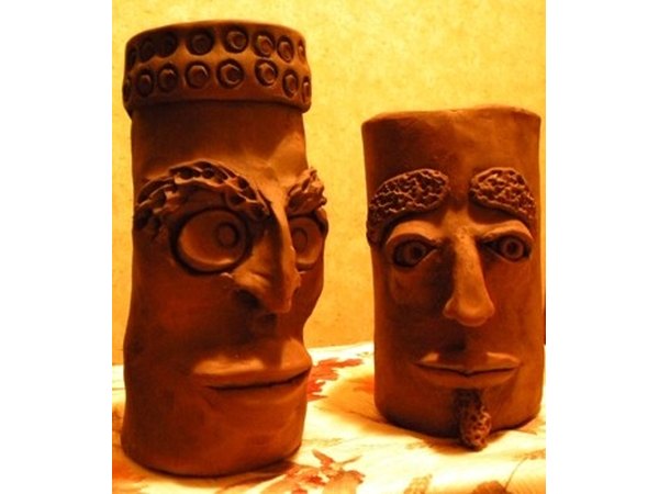 Grotesque face jugs fired in homemade outdoor kiln