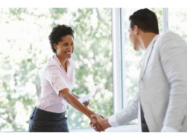 Assistant designer shaking hand in meeting