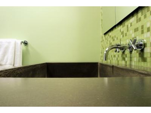 A zen bathtub surrounded by pale green walls.