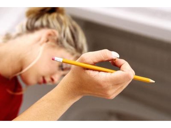 A woman holds a pencil while thinking.