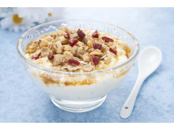Glass bowl of yogurt topped with granola.