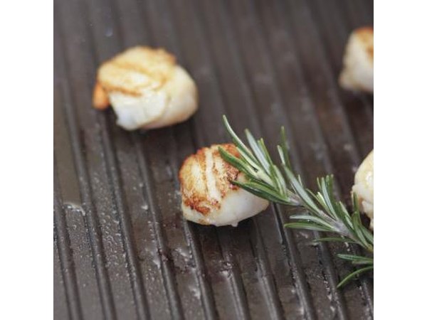 Scallops on a grill with rosemary