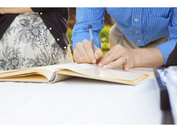Signing guestbook with pen.