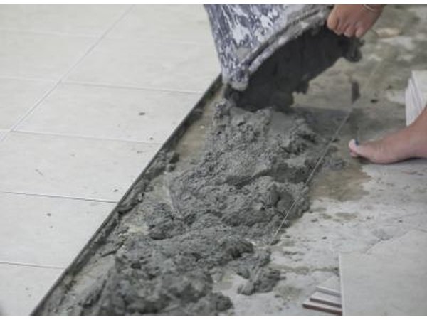 A construction worker spreads wet mortar