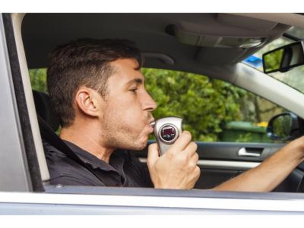 man blowing into breathalyzer