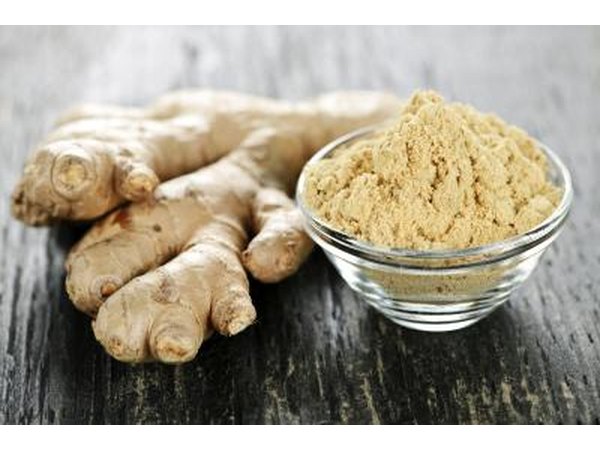 Ground ginger next to a ginger root.