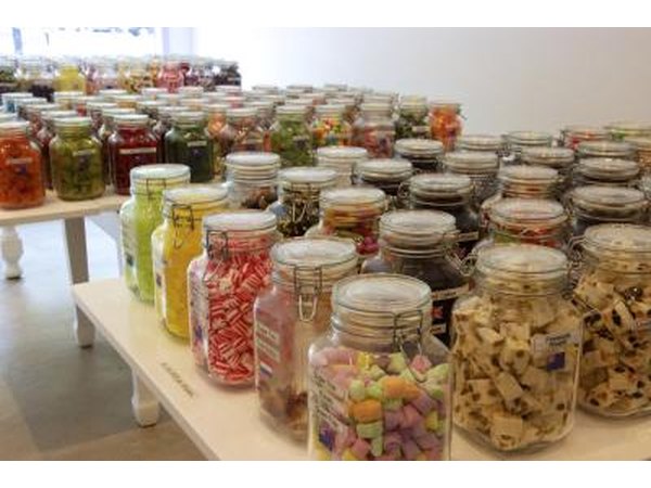 Jars of assorted bulk candies on tables in a candy store.