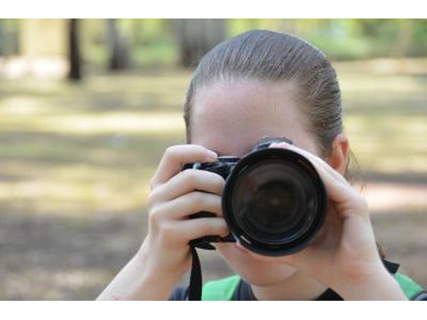 Teen girl takes photo with digital camera
