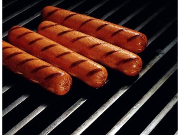 Ht dogs cooking on a grill.