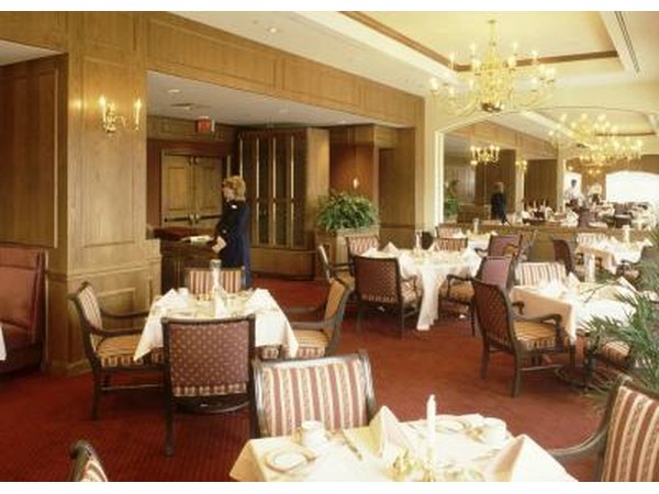 A hostess does preparatory work before dinner service starts.