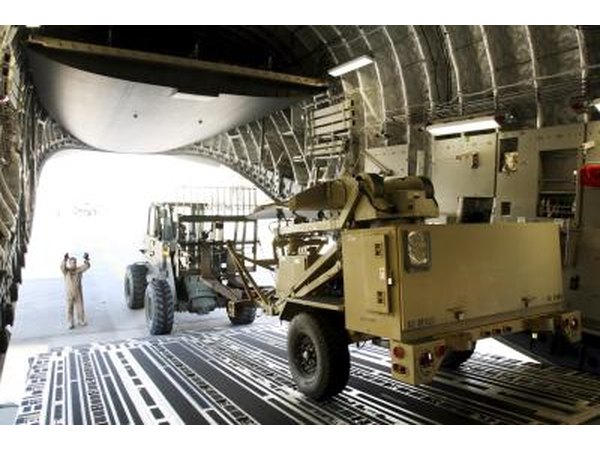 A ground surveillance radar unit is unloaded from a C-17 at Pope AFB