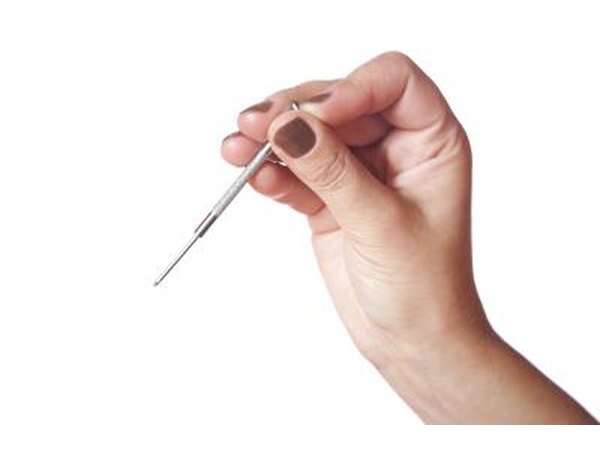 Female hand with a small screwdriver.
