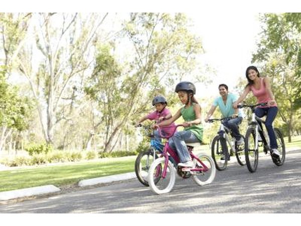 A young family riding bikes in the park.