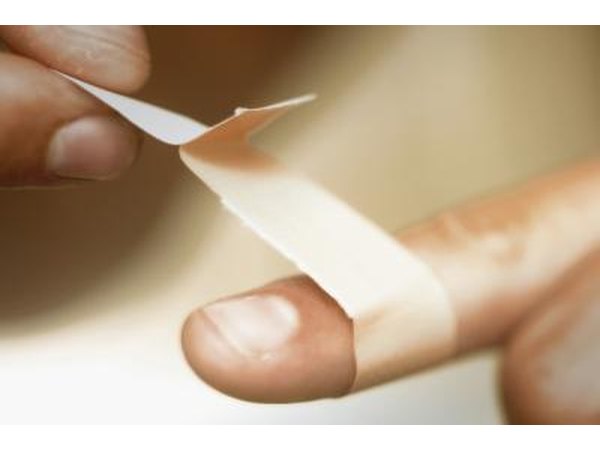 Woman putting bandaid on finger