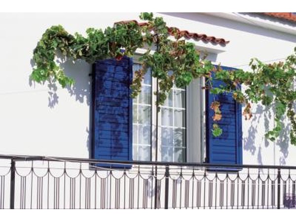 A window with bright blue shutters in Greece.