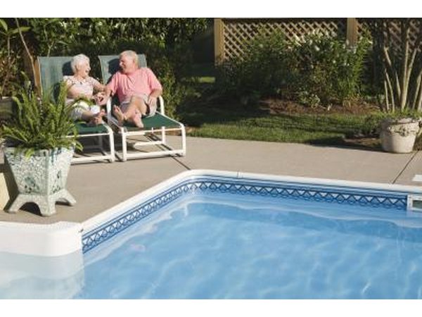 Senior couple sitting by swimming pool