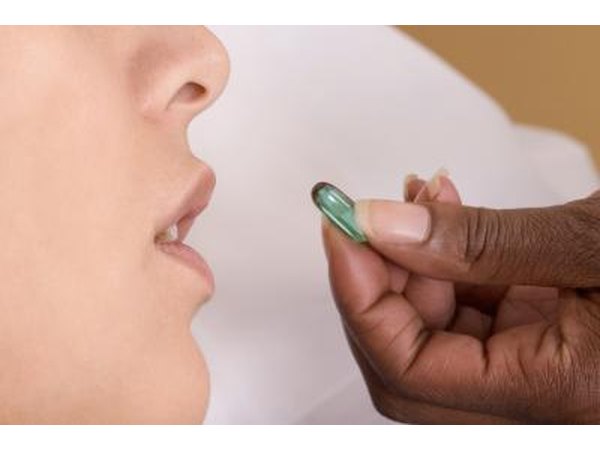 Close up of woman about to take gel cap.