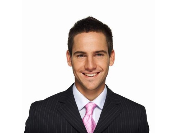 Young man smiling wearing a suit.