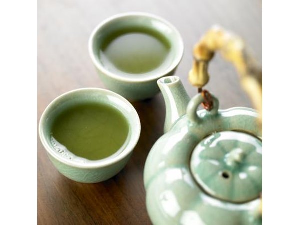 Pot and cups filled with green tea