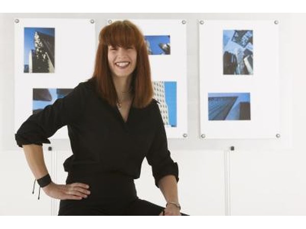 An artist is standing in front of her work.