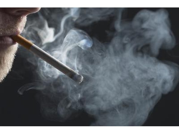 A man smokes a cigarette, smoking can lead to the swallowing of air.