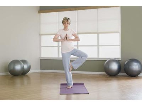 A woman balances on one foot during a yoga pose.