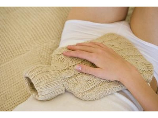 Woman holding hot water bottle on stomach
