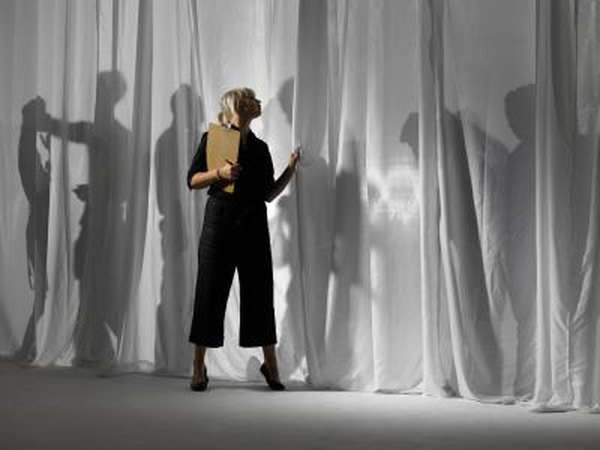 Production manager checking behind curtain