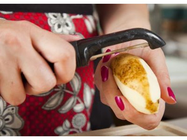 A woman peeling a potatoe