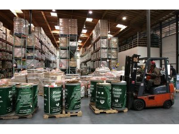 Forklift operator lifting barrels of donated food at San Francisco food bank.