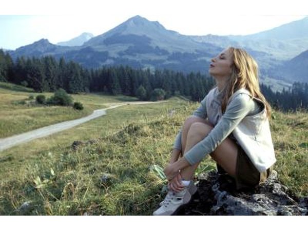 Woman sitting on rock off trail