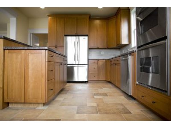 Brown tiles bring out varying shades in oak cabinets.