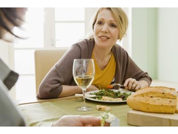 Woman at dinner table with glass of wine