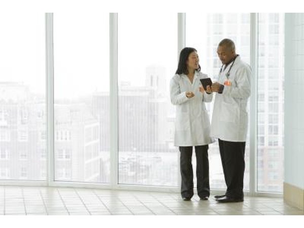 Doctors looking at tablet together in the hallway