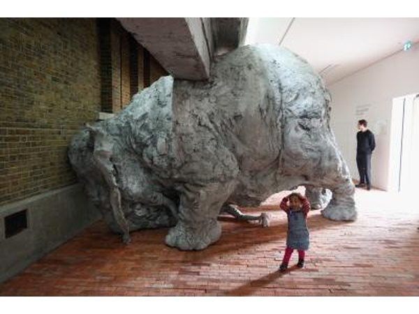 Two year old child and clay sculpture of elephant in London gallery
